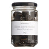 Ein Glas mit 170 g Primopasto Olive nere secche, getrocknete schwarze Oliven, mit weißem Etikett und schwarzem Deckel.