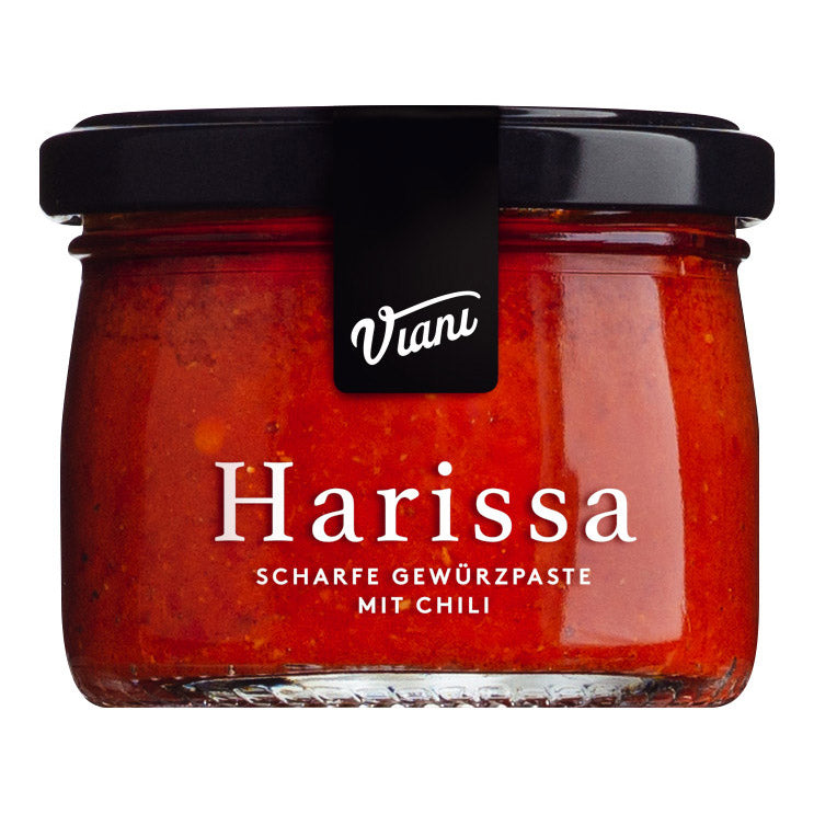 Ein Glas mit der Viani & Co. Harissa scharfe Gewürzpaste mit Chili, 100 g, mit schwarzem Deckel und weißem Text auf dem Etikett.