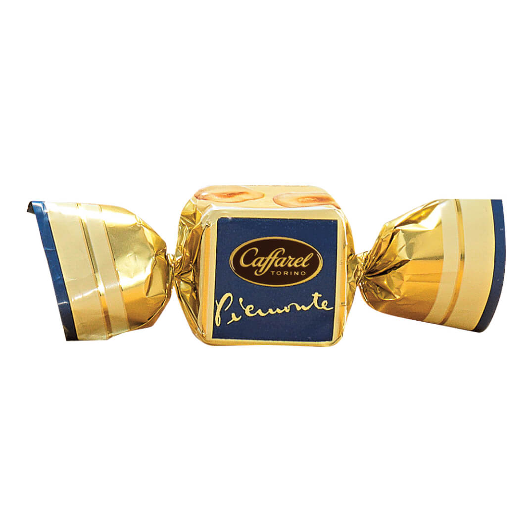 A Caffarel S.p.A. Cream-Würfel weiße Schokolade mit Haselnüssen aus dem Piemont, 100 g, goldumhüllte Praline mit blau-weißem Etikett auf weißem Grund.