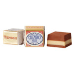 Abgebildet sind zwei verpackte und eine unverpackte Venchi Cremino 1878 Schichtpraline aus Mandel-Haselnusscreme (100 g), wobei die unverpackte Praline ihre Schichtfüllung offenbart.