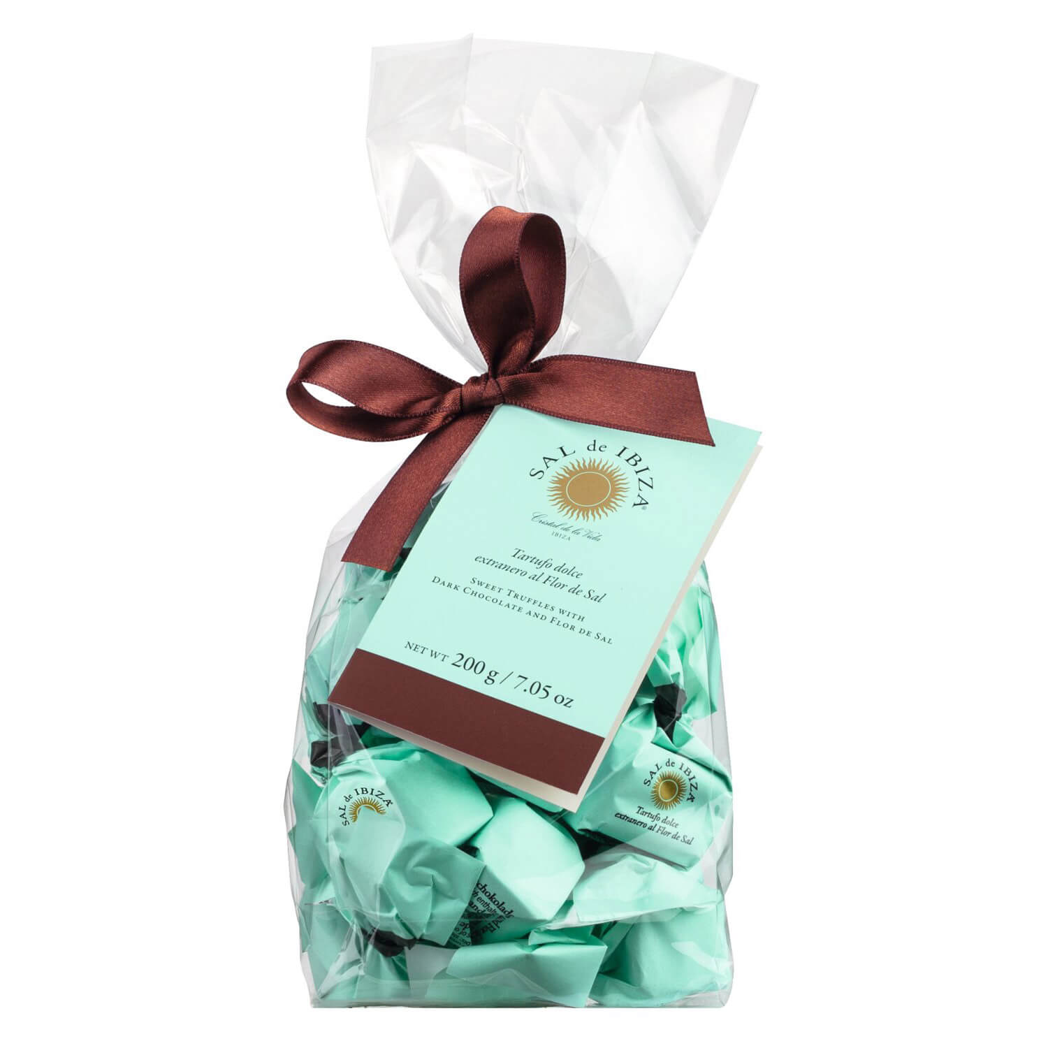 Eine durchsichtige Tüte mit Tartufi dolci extranero al Flor de Sal (200 g) von Sal de Ibiza GmbH, mit türkisfarbener Verpackung, gebunden mit einem braunen Band und einem Anhänger.