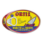 Ovale Dose Ortiz Bonito del Norte Weißflossen-Thunfisch in Olivenöl, 112 g, mit dem für die Marke Ortiz typischen gelben Etikett mit rotem Boot und Matrosenmotiv.
