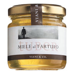 Ein 120-g-Glas Viani & Co. Miele al Tartufo, aromatischer Piemont-Honig mit Trüffel, mit goldenem Deckel und einem Etikett mit Schwarz-Weiß-Foto.