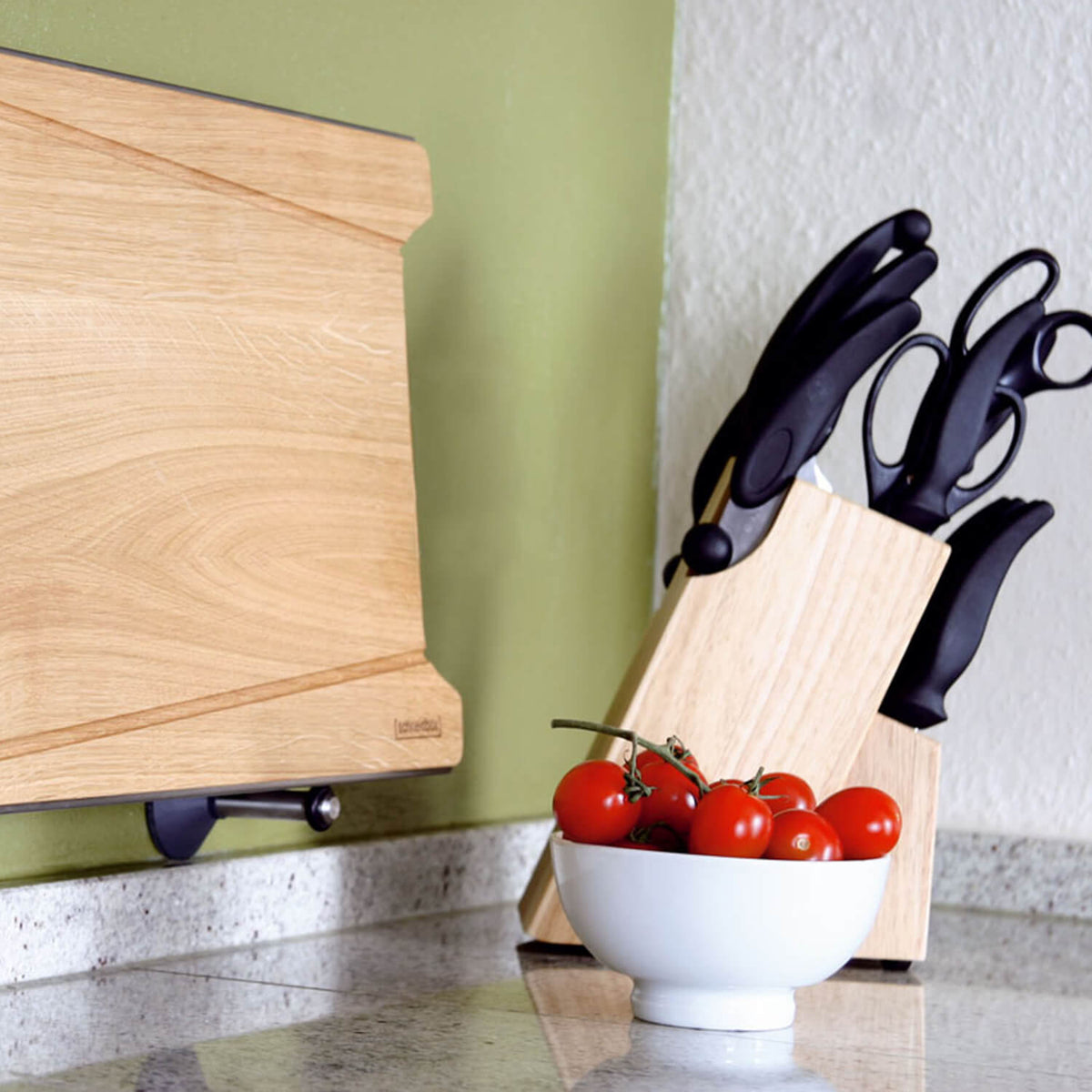 Die Schneidbox von Ideenreich Wandhalterung für Schneidbox steht zusammen mit einem hölzernen Messerblock, einer Schüssel mit Tomaten und einem hölzernen Schneidebrett auf der Küchenzeile.
