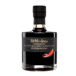 Eine 250-ml-Flasche Remodena Balsamico mit Peperoncino aus Modena IGP, auf deren Etikett eine rote Chilischote abgebildet ist.