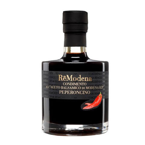 Eine 250-ml-Flasche Remodena Balsamico mit Peperoncino aus Modena IGP, auf deren Etikett eine rote Chilischote abgebildet ist.