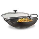 Spring Wok-Set aus Gusseisen mit Glasdeckel (Ø 35 cm) von Spring, gefüllt mit gebratenem Gemüse und Sojasprossen, auf weißem Hintergrund.
