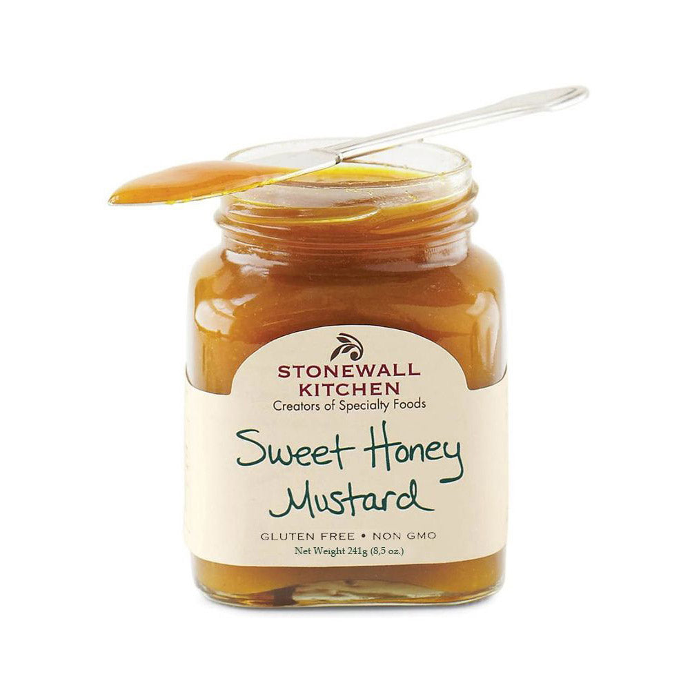 Ein Glas Stonewall Kitchen Sweet Honey Mustard (Senf mit Honig, 241 g), auf dem ein Löffel liegt.