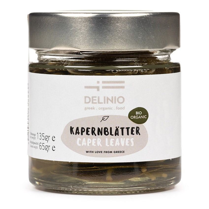 Ein 135 g Glas mit DELINIO Kapernblättern Bio aus Griechenland mit einem silbernen Deckel, der Kapernblätter in Salzlake zeigt.