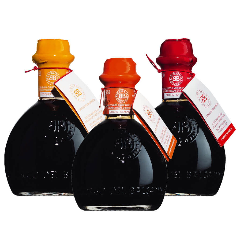 Das Il Borgo del Balsamico 3er Aceto Balsamico di Modena IGP Probierpaket enthält drei 250-ml-Flaschen, jede mit einem roten, gelben oder orangenen Wachssiegel und einem Anhänger.