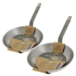 Zwei De Buyer Bratpfannen (Mineral B Element Iron, 26 & 32 cm) mit langen Griffen, jeweils mit brauner Kartonverpackung im Inneren.